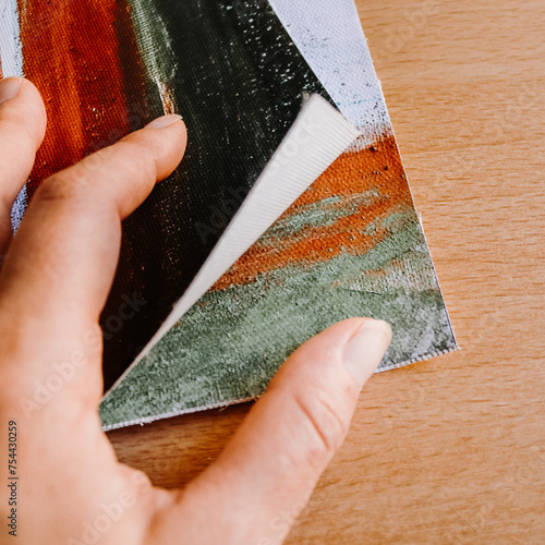 Close up of hand holding canvas fine art print abstract art blank clean wood background