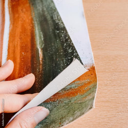 Close up of hand holding canvas fine art print abstract art blank clean wood background