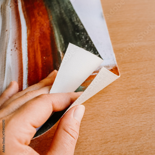 Close up of hand holding canvas fine art print abstract art blank clean wood background
