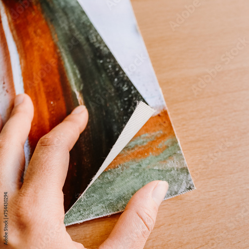 Close up of hand holding canvas fine art print abstract art blank clean wood background