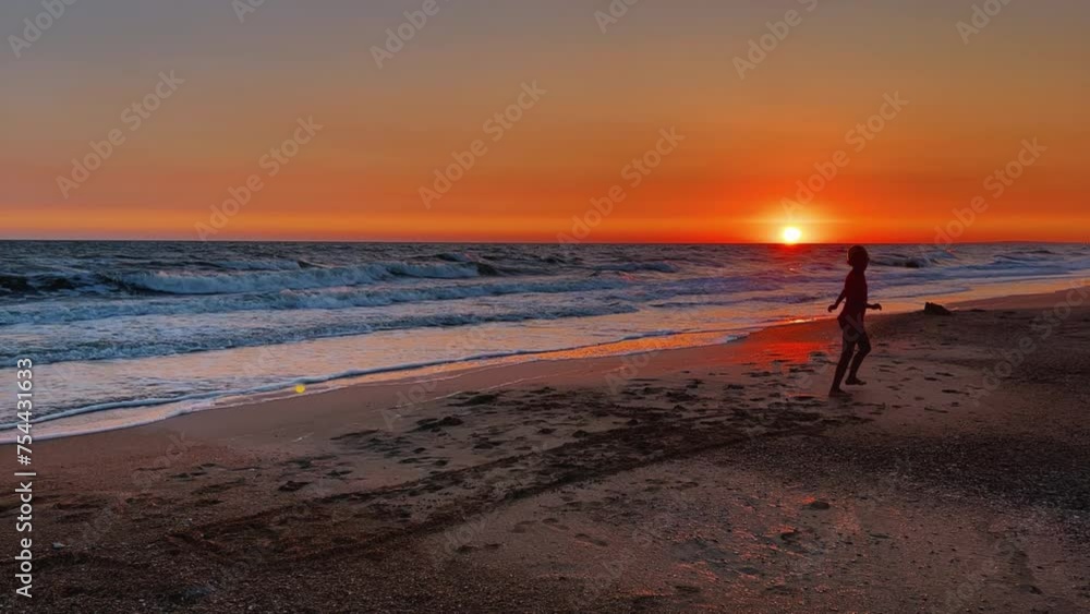 Relaxing by the sea. Shell beach. Footprints on the seawater. A child on the beach of the Sea of Azov. A boy jumps into the sea waves from the beach. The delight of a child from a vacation at sea. 4K Relaxing by the sea. Shell beach. Footprints on the seawater. A child on the beach of the Sea of Azov. A boy jumps into the sea waves from the beach. The delight of a child from a vacation at sea. 4K