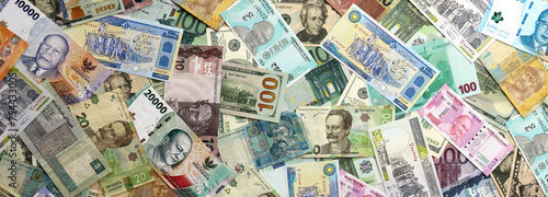 Many banknotes of different currency. Background of big amount of random money bills close up