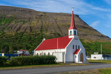 Scenic view of church with mountain in background in small town Þingeyri in Westfjords, Iceland.