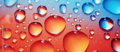 Close-up using a macro lens captures water droplets on a plastic sheet, creating an abstract and vibrant red and blue background.