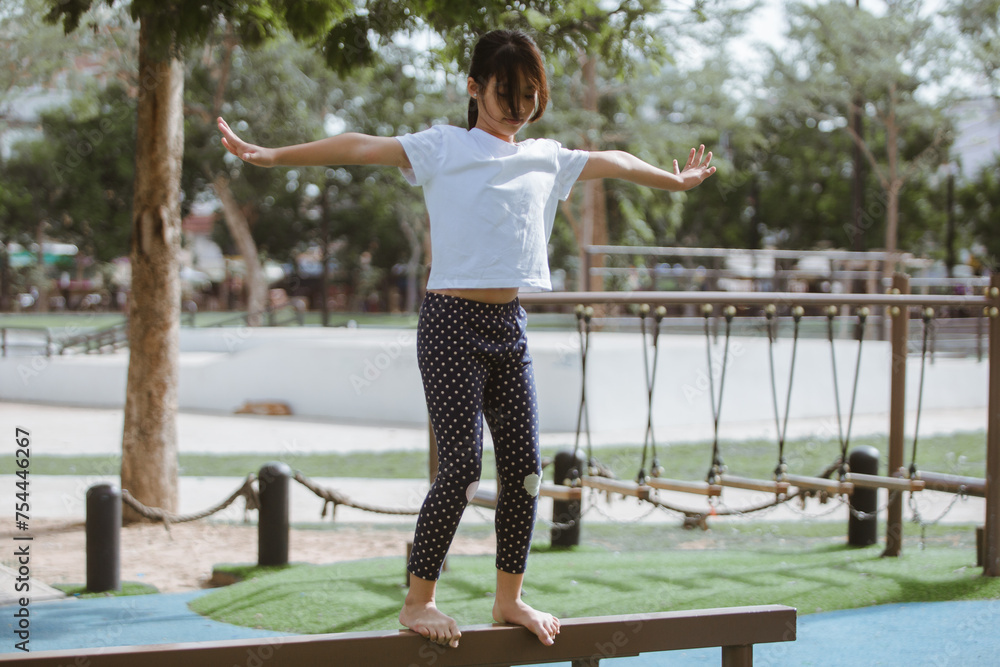 Young asian woman practicing yoga in the park. Healthy lifestyle concept.