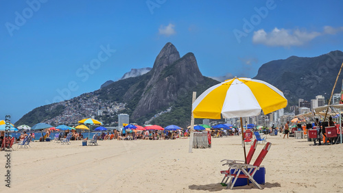  Beach umbrella ready for beachgoer on Ipanema beach Rio de Janeiro with Dois Irmaos in the background.