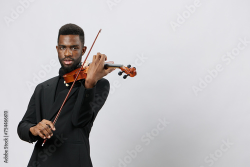 Elegant African American Man Playing the Violin in Tuxedo on White Background