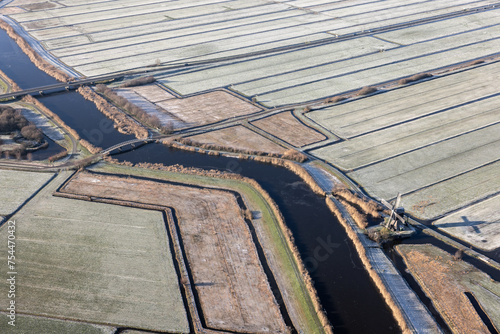 Aerial view dutch landscape with frozen meadows and ditches