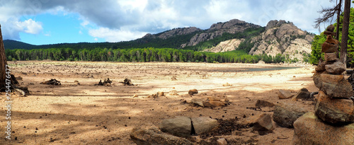 Near Porto-Vecchio, in the heart of Alta Rocca, Lake U Spidali is nestled between road and mountains. Due to the drought, the water level has dropped, revealing tree stumps cut before impoundment