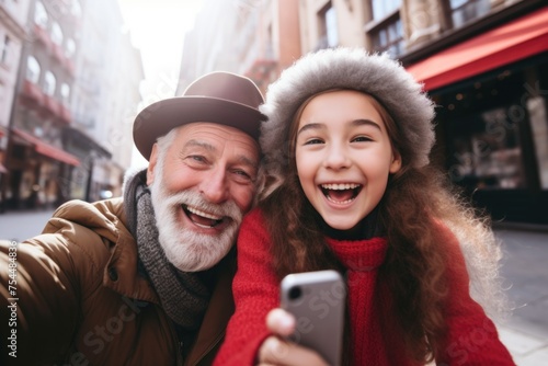 An older man and a young girl taking a selfie. Suitable for family and technology concepts