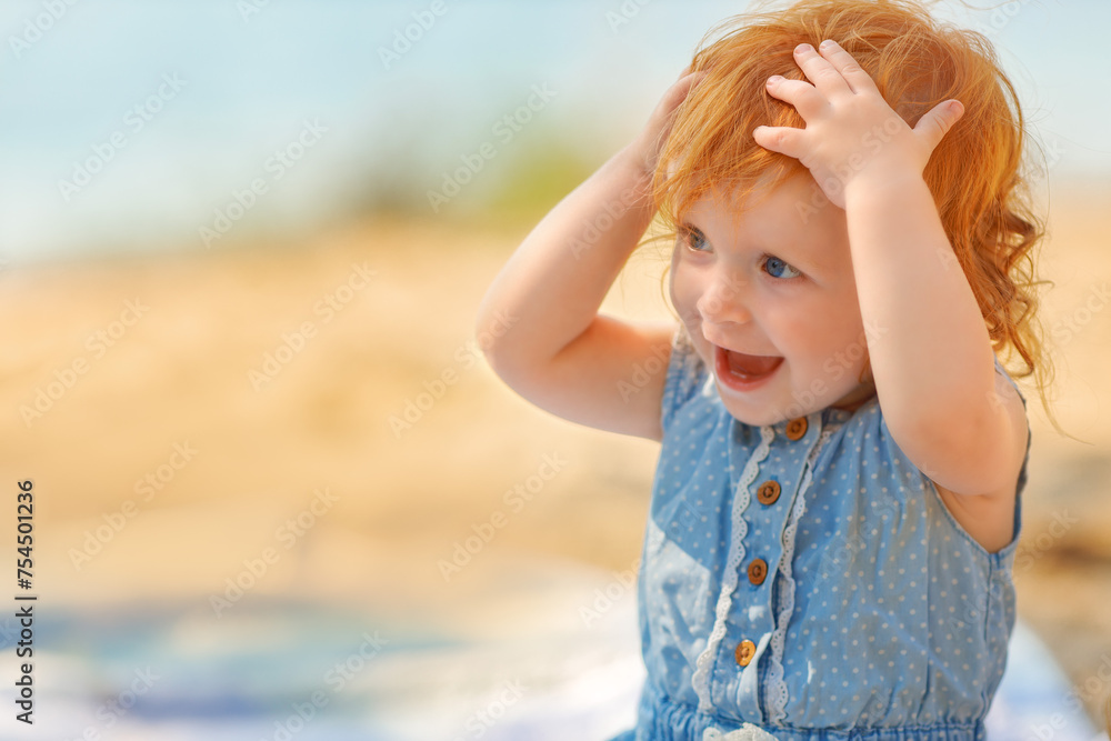 Portrait of redhair baby sitting in the sea water, summer activity. Surprised girl. Portrait of redhair baby sitting in the sea water, summer activity. Surprised girl.