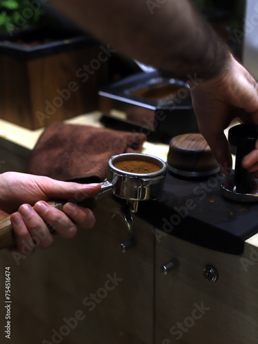 barista trabajando el café con prensador y filtro de cafetera photo