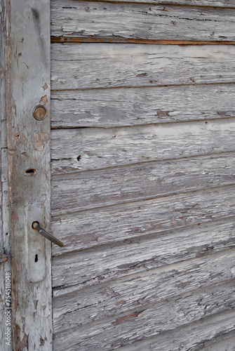 Stare drewniane drzwi z metalową klamką. Tło i tekstura drewniane deski © Radosaw