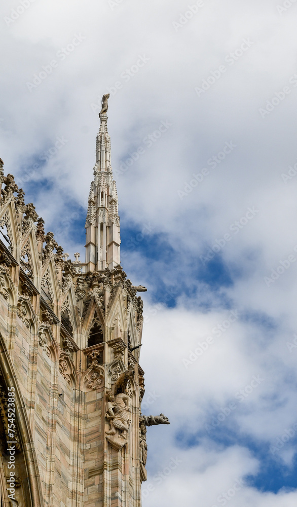 Detail of the Milan Cathedral with one of 135 spires that soar over its rooftop, its construction began in 1386 and the final details were completed only in 1965, Milan, Lombardy, Italy