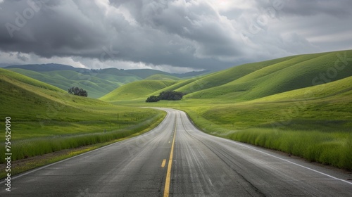 green grass on each side of highway, rolling hills in front with clouds, towards paso robles 