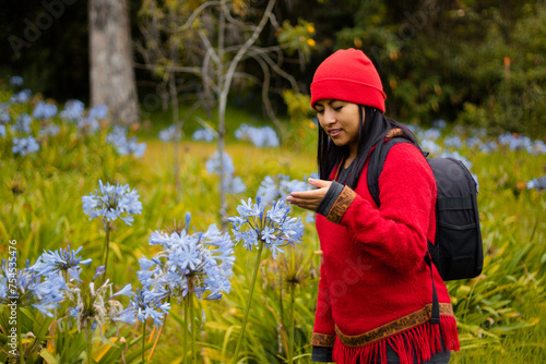 Explorando la belleza invernal,Una joven aventurera admira las flores en el campo bajo la lluvia de invierno,estilo de vida photo