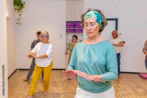 Concentrated woman exercising during qi gong class photo