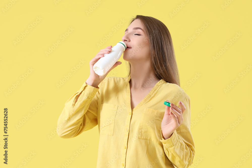 Young woman drinking tasty yoghurt on yellow background Young woman drinking tasty yoghurt on yellow background