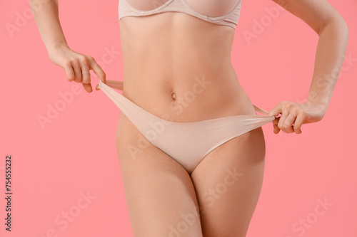 Beautiful young woman in stylish beige underwear on pink background, closeup