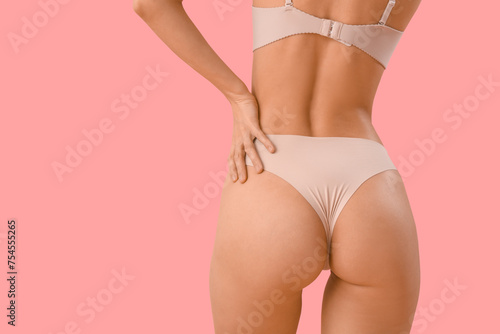 Beautiful young woman in stylish beige underwear on pink background, back view