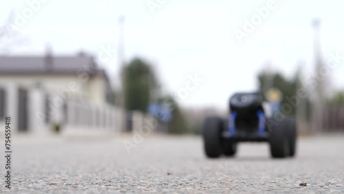 a radio-controlled car starts and drives off along an asphalt road  photo