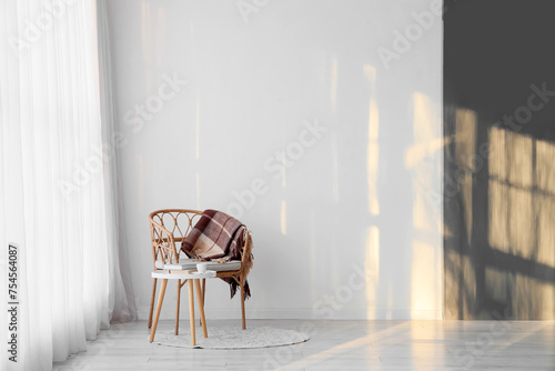 Interior of room with light curtain, armchair and table