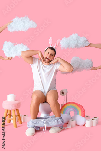 Young man in bunny ears sit...