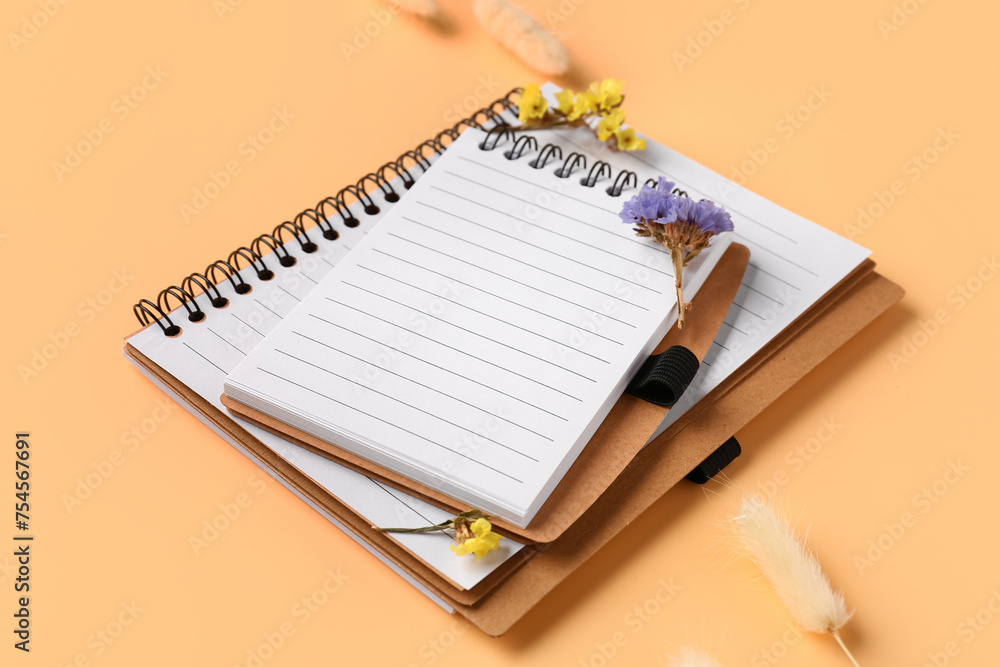 Notebooks and flowers on beige background Notebooks and flowers on beige background