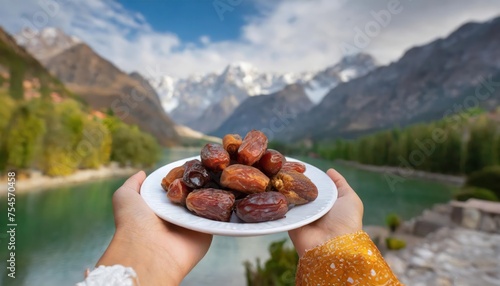 Concept Giving or Charity during Ramadhan Holy Month, Female Muslim Hand Over A Plate of Dates Fruit  hurma to Other. Ifthar and Ramadan Kareem Concepts. photo