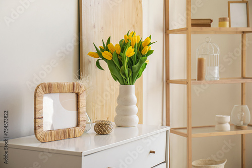 Beautiful vase with tulips on chest of drawers in living room