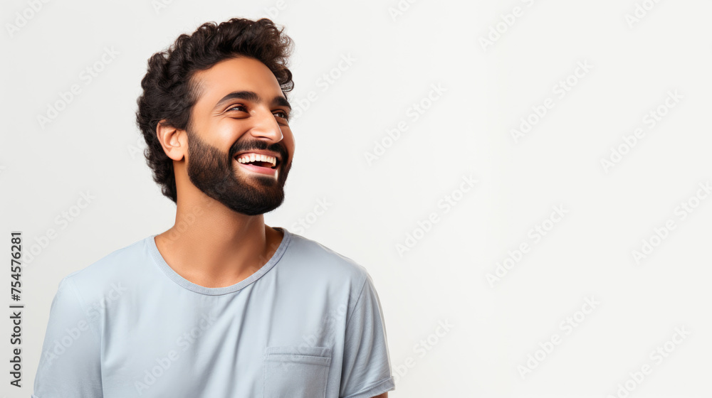 Joyful man with a beard and curly hair, laughing and looking away against a white background. - obrazy, fototapety, plakaty 