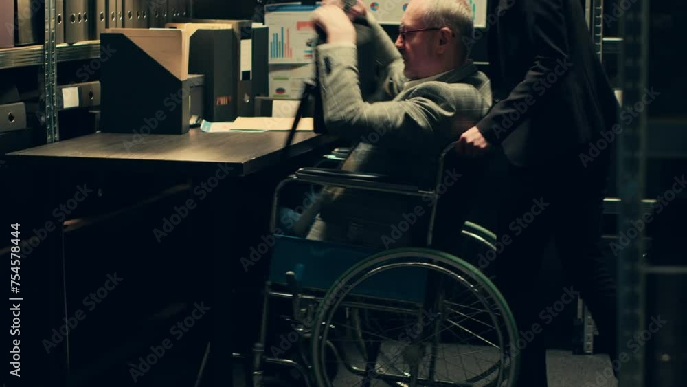 Inspector wheelchair user analyzes geographical maps or data for crime scene reconstructions, helping his colleagues with details in events timeline. Senior detective with disability. Camera A. Inspector wheelchair user analyzes geographical maps or data for crime scene reconstructions, helping his colleagues with details in events timeline. Senior detective with disability. Camera A.