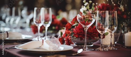 A table is adorned with numerous empty glasses, plates, and napkins, all set up for a festive occasion like weddings, birthdays, or Christmas celebrations. The setting exudes a restaurant interior