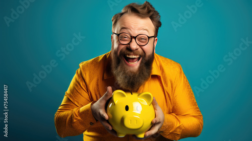 Smiling middle age man holding a piggybank