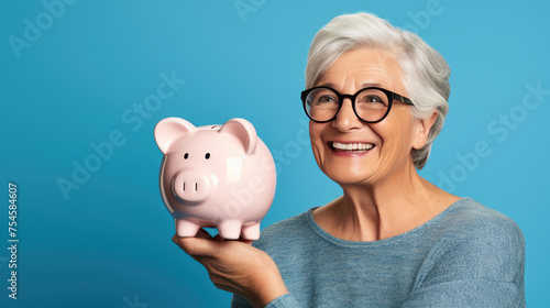 Cheerful senior woman holding a piggy bank, symbolizing savings and financial security in retirement.