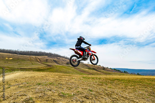 Motocross rider navigating dirt road on motorcycle with helmet