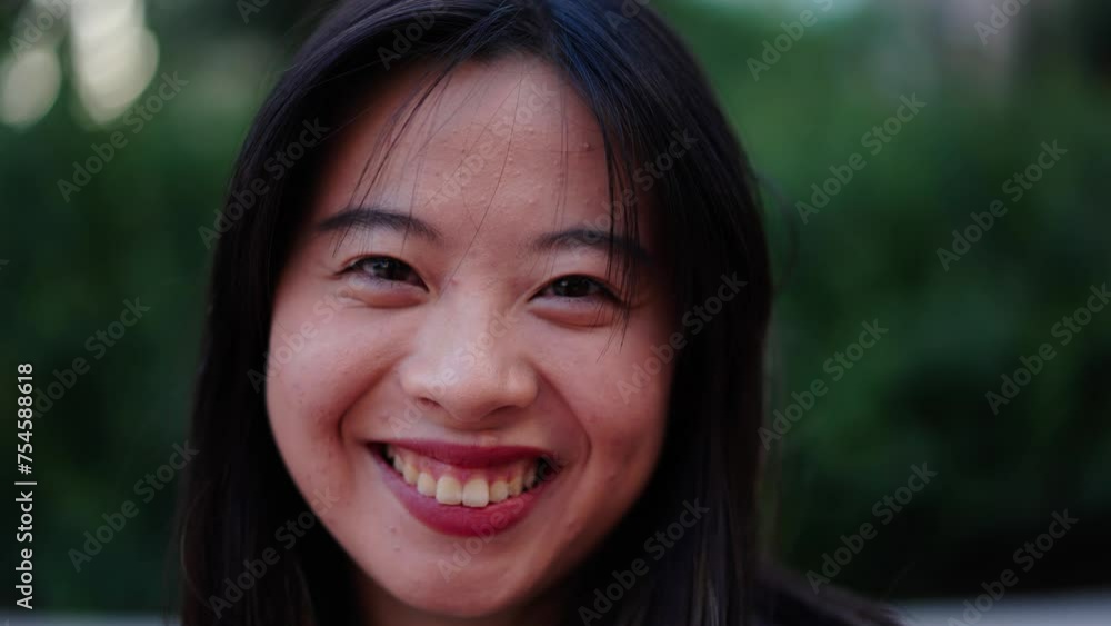 Close up beautiful Asian nice young woman smiling with friendly expression looking joyful at camera outdoor. Generation z pretty Chinese female with brown eyes and black hair posing cheerful portrait Close up beautiful Asian nice young woman smiling with friendly expression looking joyful at camera outdoor. Generation z pretty Chinese female with brown eyes and black hair posing cheerful portrait