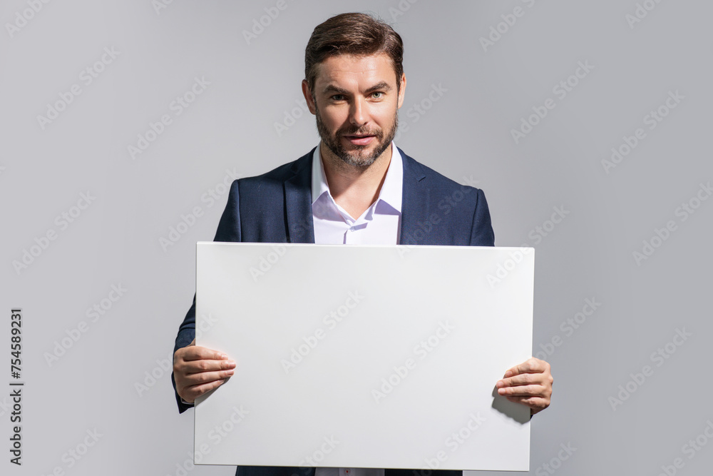 Business man with blank banner ad on studio background. Portrait of attractive man holding empty blank poster. Man showing blank poster. Male presenting signboard, billboard or banner with copy space. Business man with blank banner ad on studio background. Portrait of attractive man holding empty blank poster. Man showing blank poster. Male presenting signboard, billboard or banner with copy space.