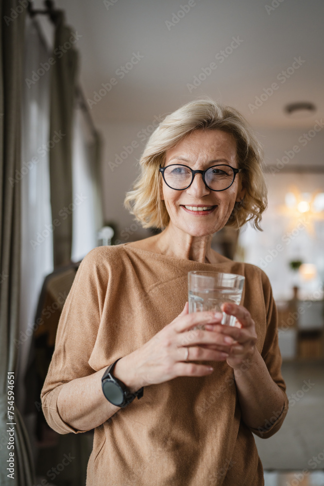 Close up portrait of one mature woman with glass of water at home Close up portrait of one mature woman with glass of water at home