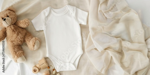 White cotton baby bodysuit with short sleeves, accompanied by a plush teddy bear and wooden toys, set against a soft beige fabric background, capturing the essence of infancy.