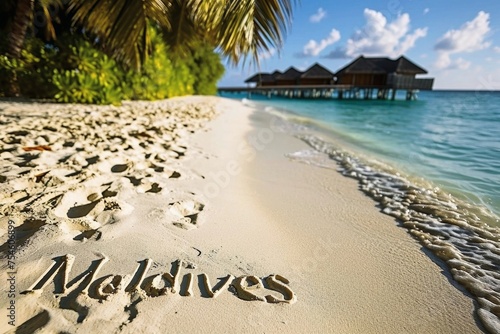 The word Maldives written in the sand on a tropical beach. photo