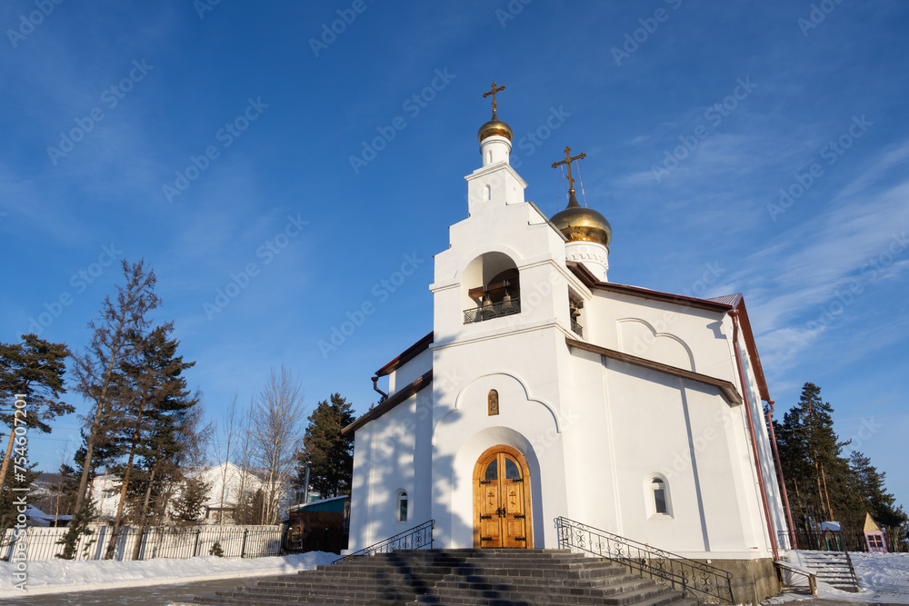 View of a beautiful church. The building of a white Orthodox church against a blue sky. Kazan Cathedral, Severobaikalsk city, Republic of Buryatia, Russia. Christianity in Siberia.