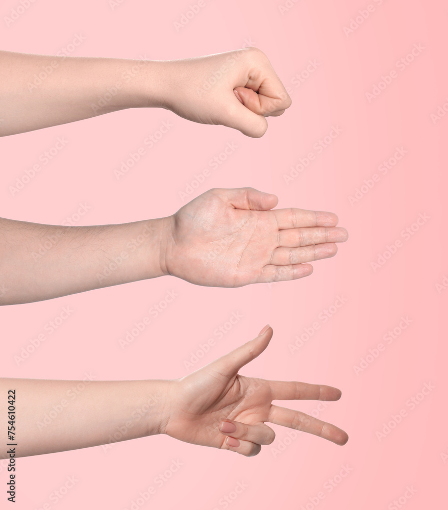 People playing rock, paper and scissors on pink background, closeup