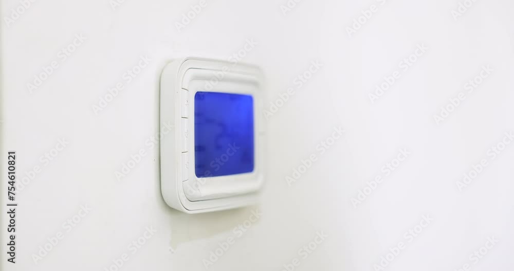 Unrecognizable female using modern smart home system mounted on wall, presses button, managing temperature inside, activating security alarm, safety features. Smarthome for comfort life and protection Unrecognizable female using modern smart home system mounted on wall, presses button, managing temperature inside, activating security alarm, safety features. Smarthome for comfort life and protection