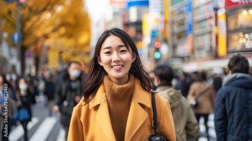 Asian woman shopping in the Shibuya district, Tokyo, Japan with the crowd of people walking in the city. Attractive girl enjoys and fun outdoor lifestyle travel city in autumn holiday vacation