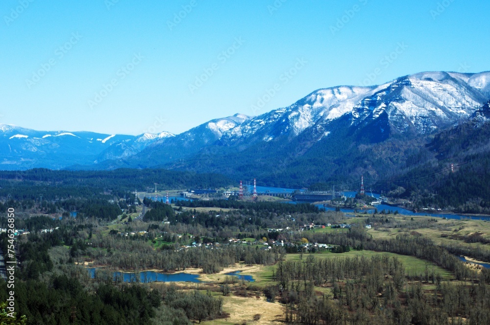 Aerial View of North Bonneville, Bridge of the Gods, and the snow covered Cascade mountain range, on a clear sunny day. 