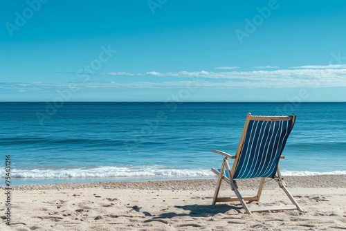 Beach chair on the sandy shore in front of the sea © InfiniteStudio