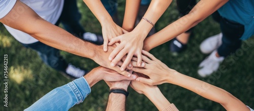 close up of stacked human hands showing working together to build a business.