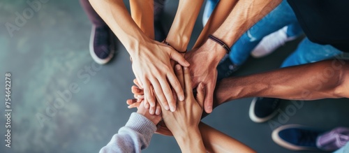 close up of stacked human hands showing working together to build a business. photo