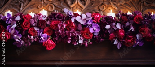 A variety of purple and red flowers arranged in a bouquet and placed on a mantle as a decorative element for a wedding reception.